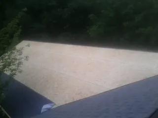 New OSB roof sheathing installed beside an existing shingle roof in Alberta