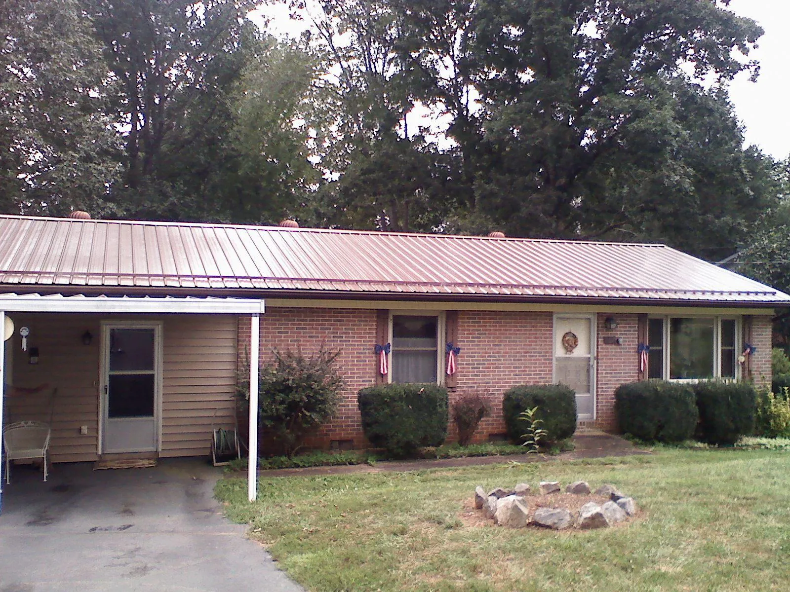 Bronze metal roof and carport on a brick ranch home — Roof Repair work by our crew in Alberta
